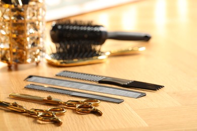 Photo of Hairdresser tools. Different scissors and combs on wooden table, closeup