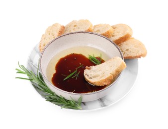 Photo of Bowl of balsamic vinegar with oil, rosemary and bread slices on white background