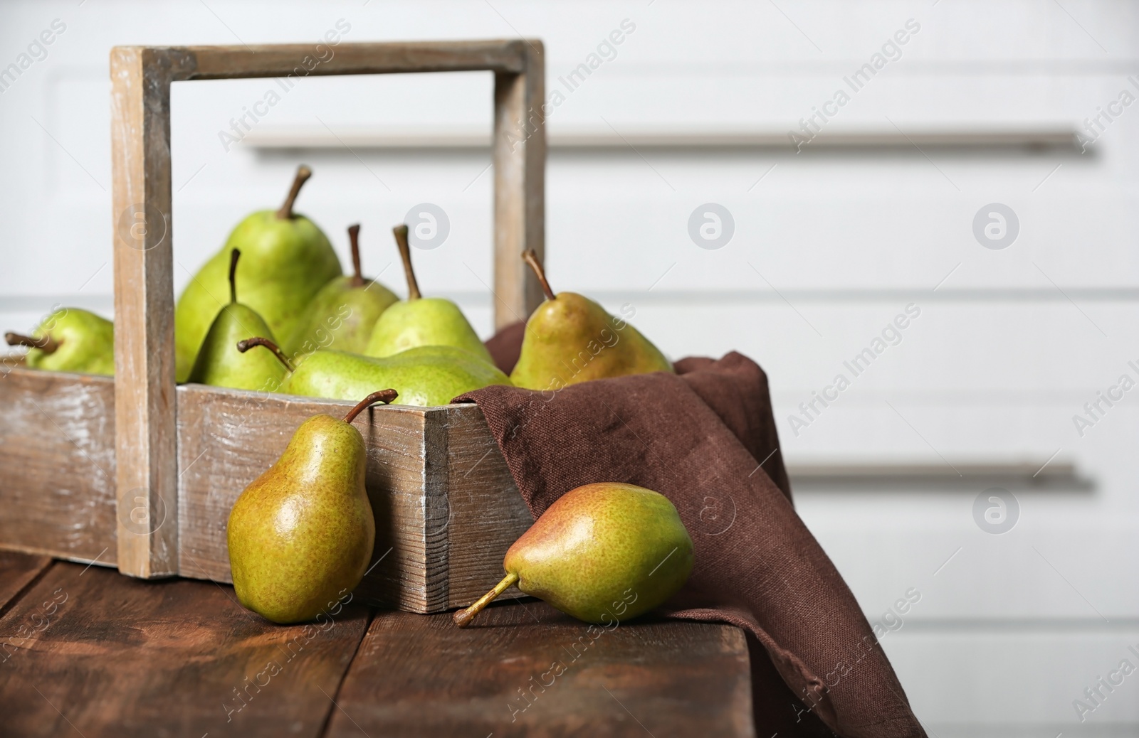 Photo of Basket with ripe pears on wooden table