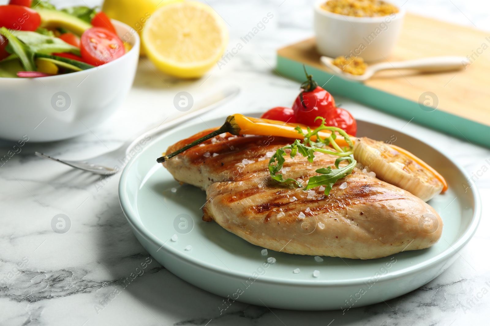 Photo of Tasty grilled chicken fillets with arugula and salt on white marble table, closeup