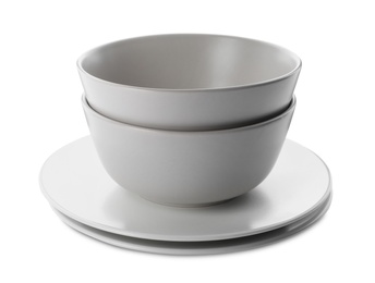 Stack of clean plates and bowls on white background