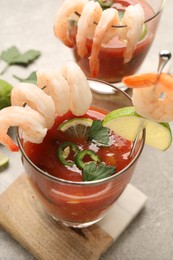 Tasty shrimp cocktail with sauce in glasses and lime on light table, closeup