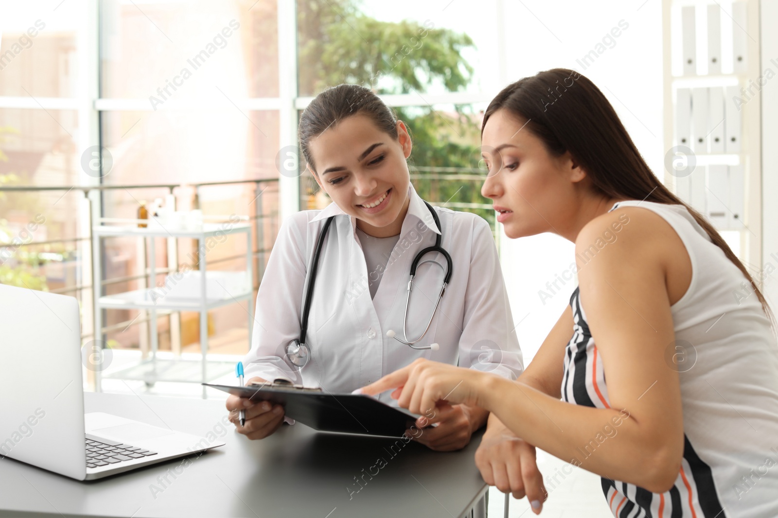 Photo of Young doctor consulting patient in modern hospital