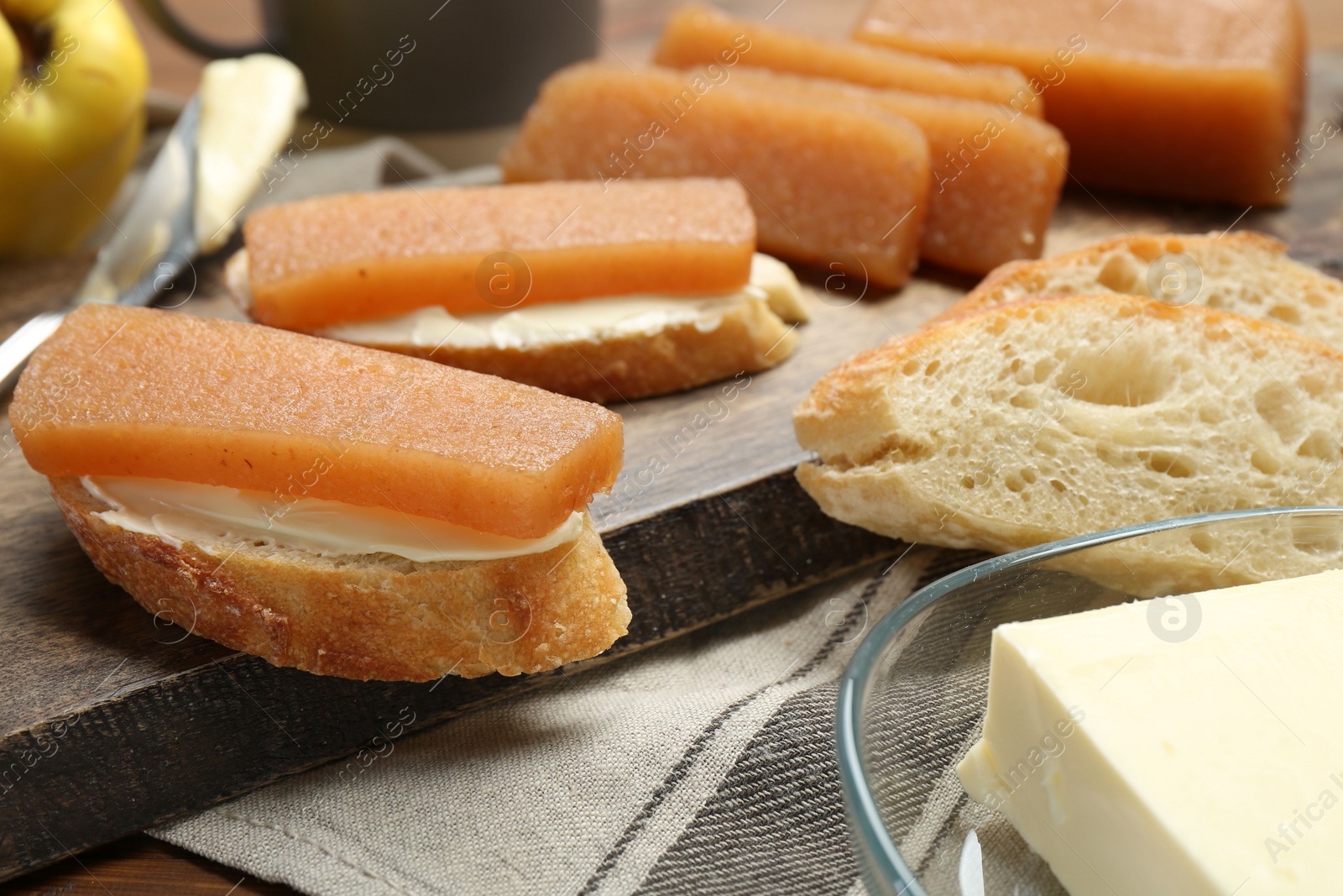 Photo of Quince paste sandwiches and fresh fruit on table, closeup