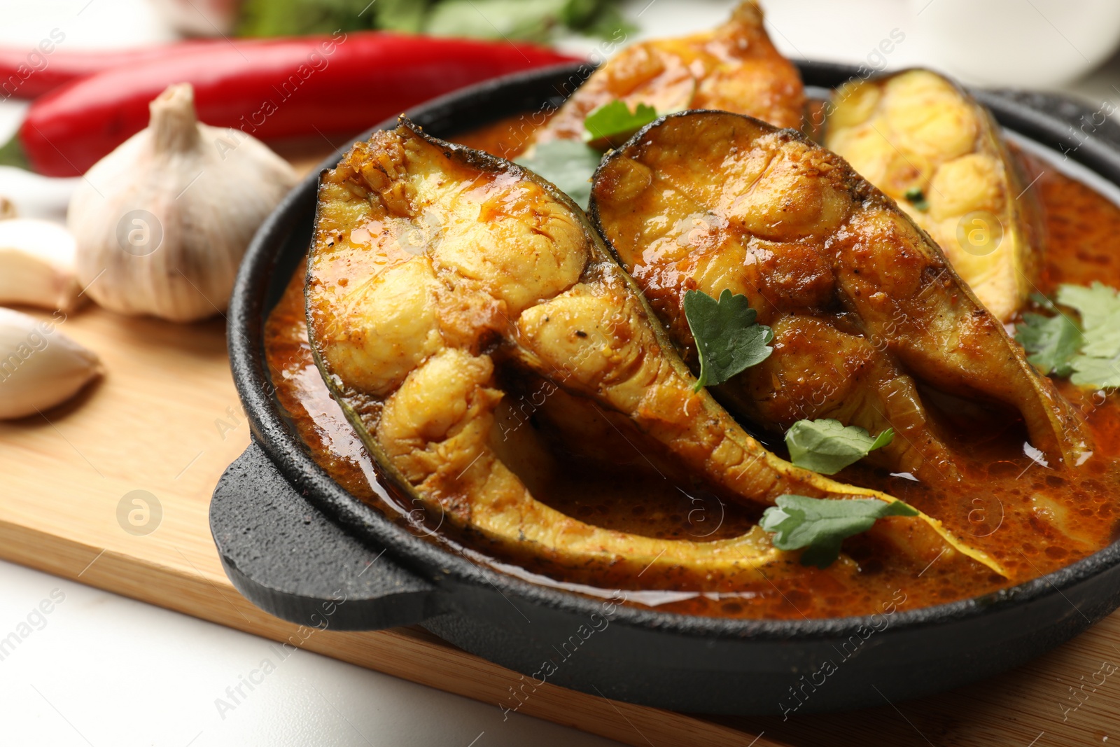 Photo of Tasty fish curry on table, closeup. Indian cuisine