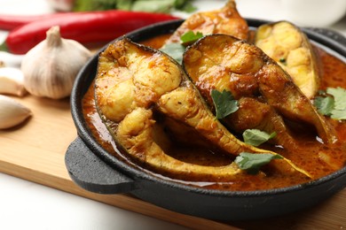 Photo of Tasty fish curry on table, closeup. Indian cuisine