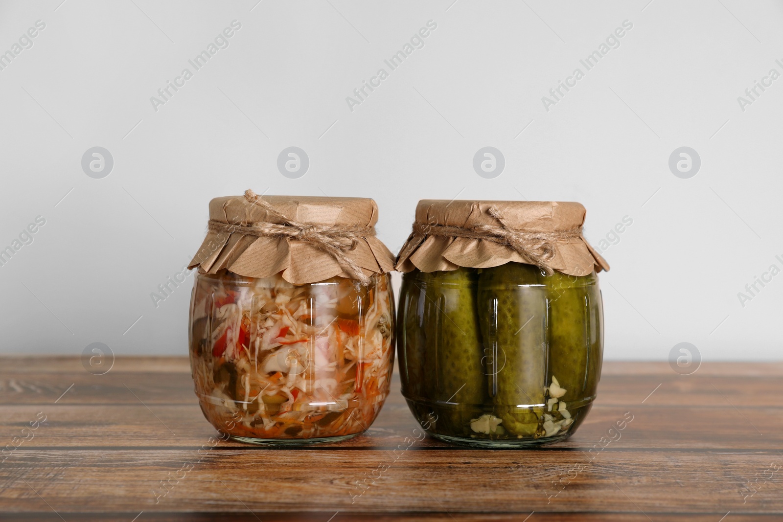 Photo of Jars with pickled vegetables on wooden table