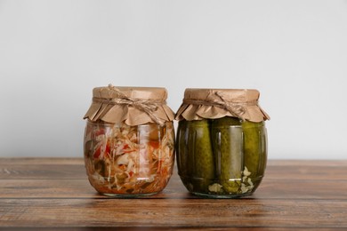 Jars with pickled vegetables on wooden table