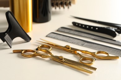 Hairdresser tools. Different scissors and combs on white table, closeup