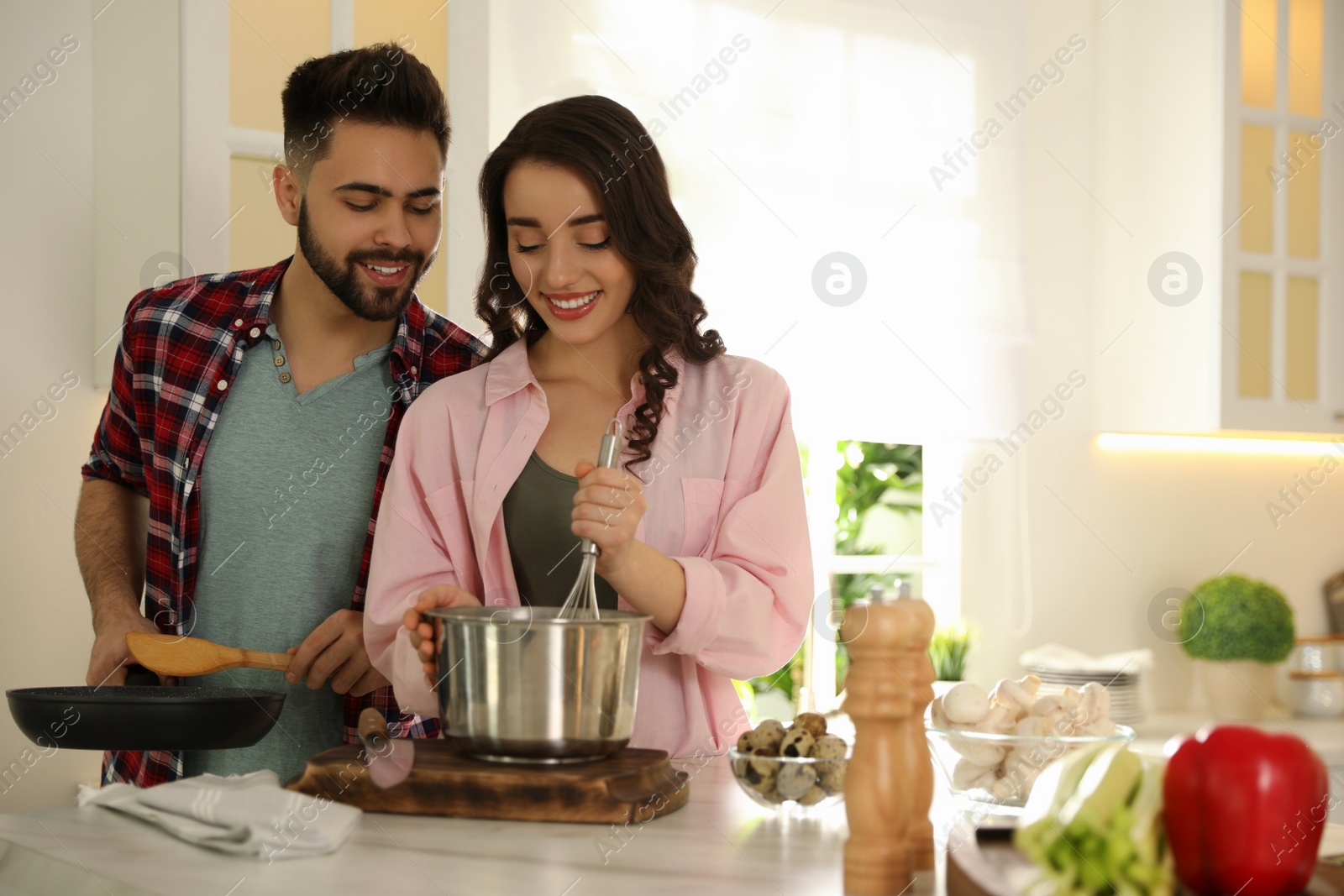 Photo of Lovely young couple cooking together in kitchen