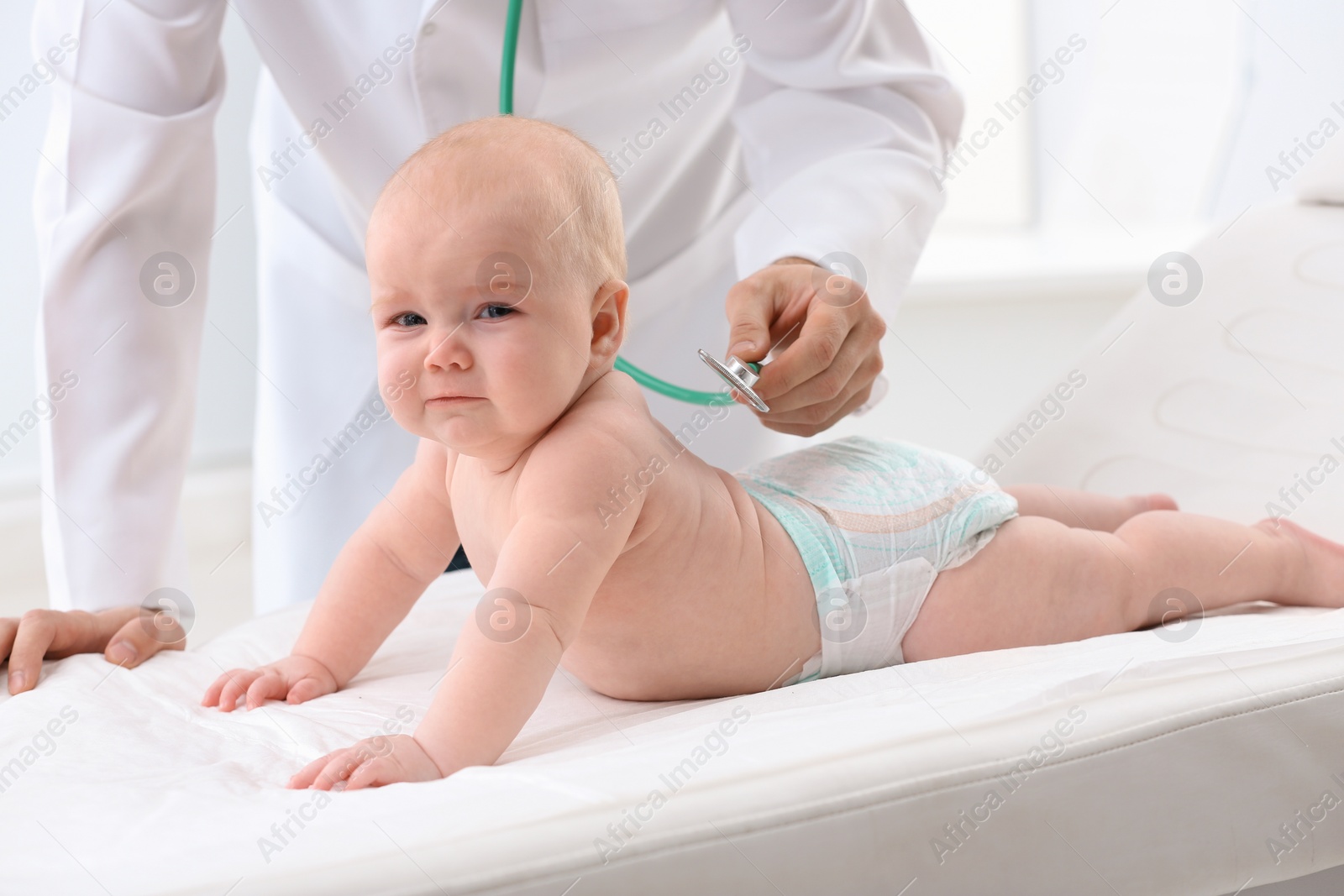 Photo of Children's doctor examining baby with stethoscope in hospital