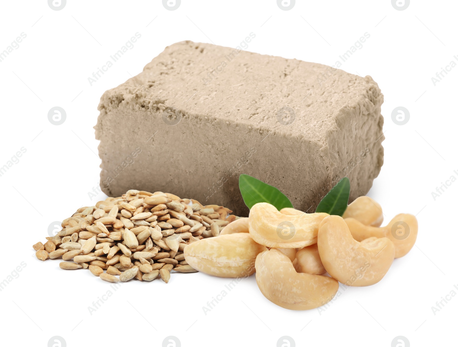 Image of Tasty halva, peeled sunflower seeds, cashew nuts and green leaves isolated on white