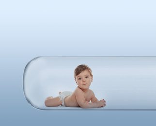 Little baby in test tube on light blue background