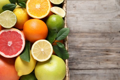 Different cut and whole citrus fruits on wooden table, top view. Space for text