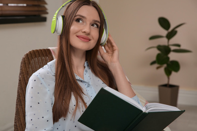 Photo of Woman listening to audiobook in chair at home