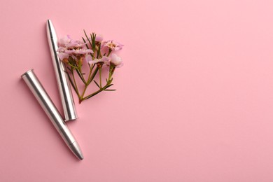 Photo of Bullets and beautiful flowers on pink background, flat lay. Space for text