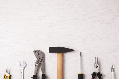 Photo of Flat lay composition with construction tools on white wooden background. Space for text