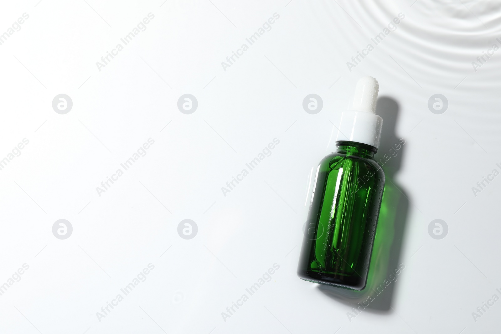 Photo of Bottle of cosmetic product on white background, top view. Space for text