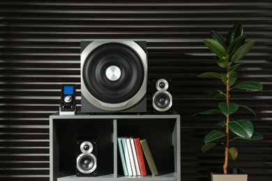 Photo of Modern audio speaker system on shelving indoors