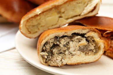 Delicious baked patties with meat and mushrooms on white wooden table, closeup