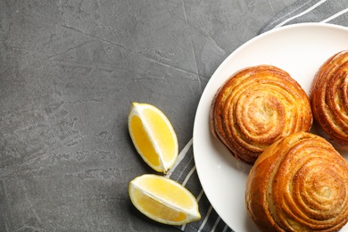 Photo of Flat lay composition with buns and space for text on grey stone background. Fresh from oven