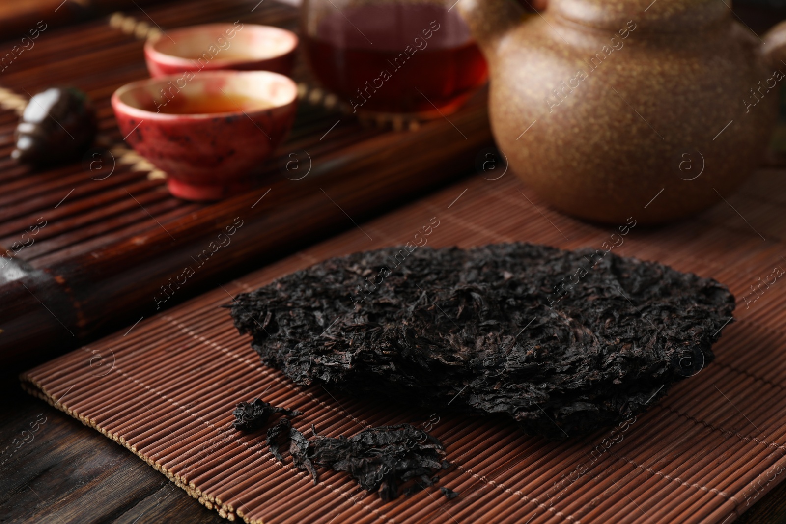 Photo of Broken disc shaped pu-erh tea on wooden table