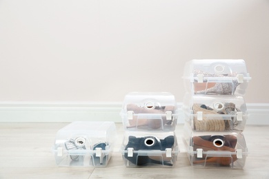 Photo of Shoes in plastic boxes near light wall. Storage organization