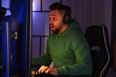 Photo of Man playing video games on computer at table indoors