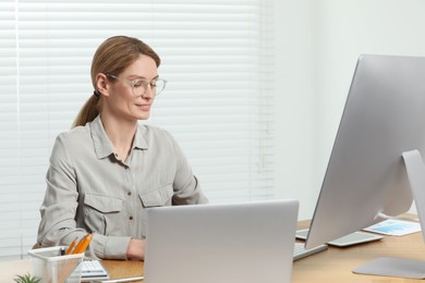 Professional accountant working at wooden desk in office