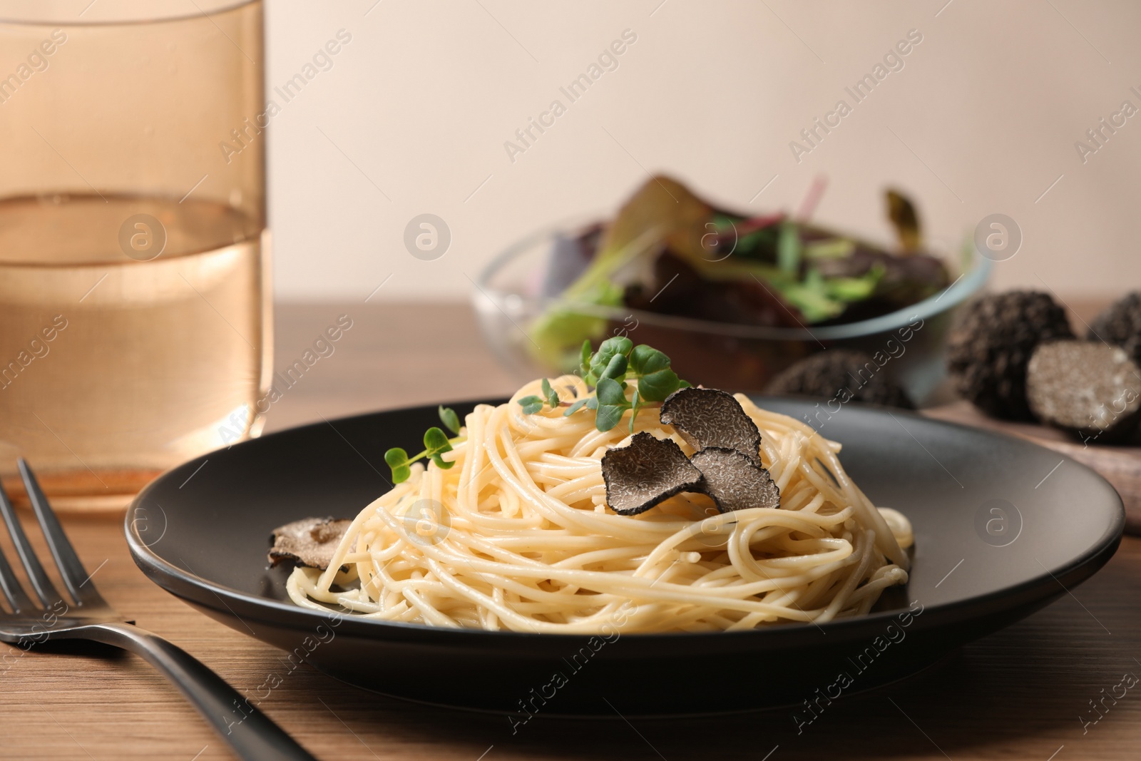 Photo of Tasty spaghetti with truffle on wooden table