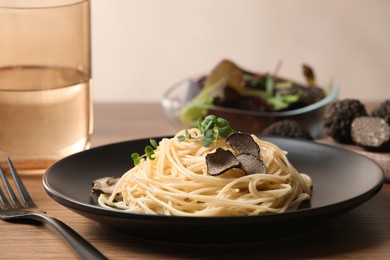 Tasty spaghetti with truffle on wooden table