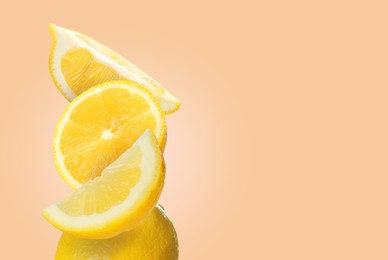 Image of Stack of cut and whole fresh lemons on pale coral background, space for text