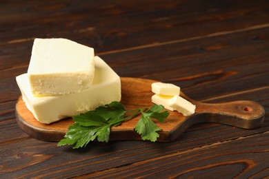 Photo of Tasty butter and parsley on wooden table