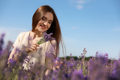 Photo of Young woman with lavender bouquet in field on summer day