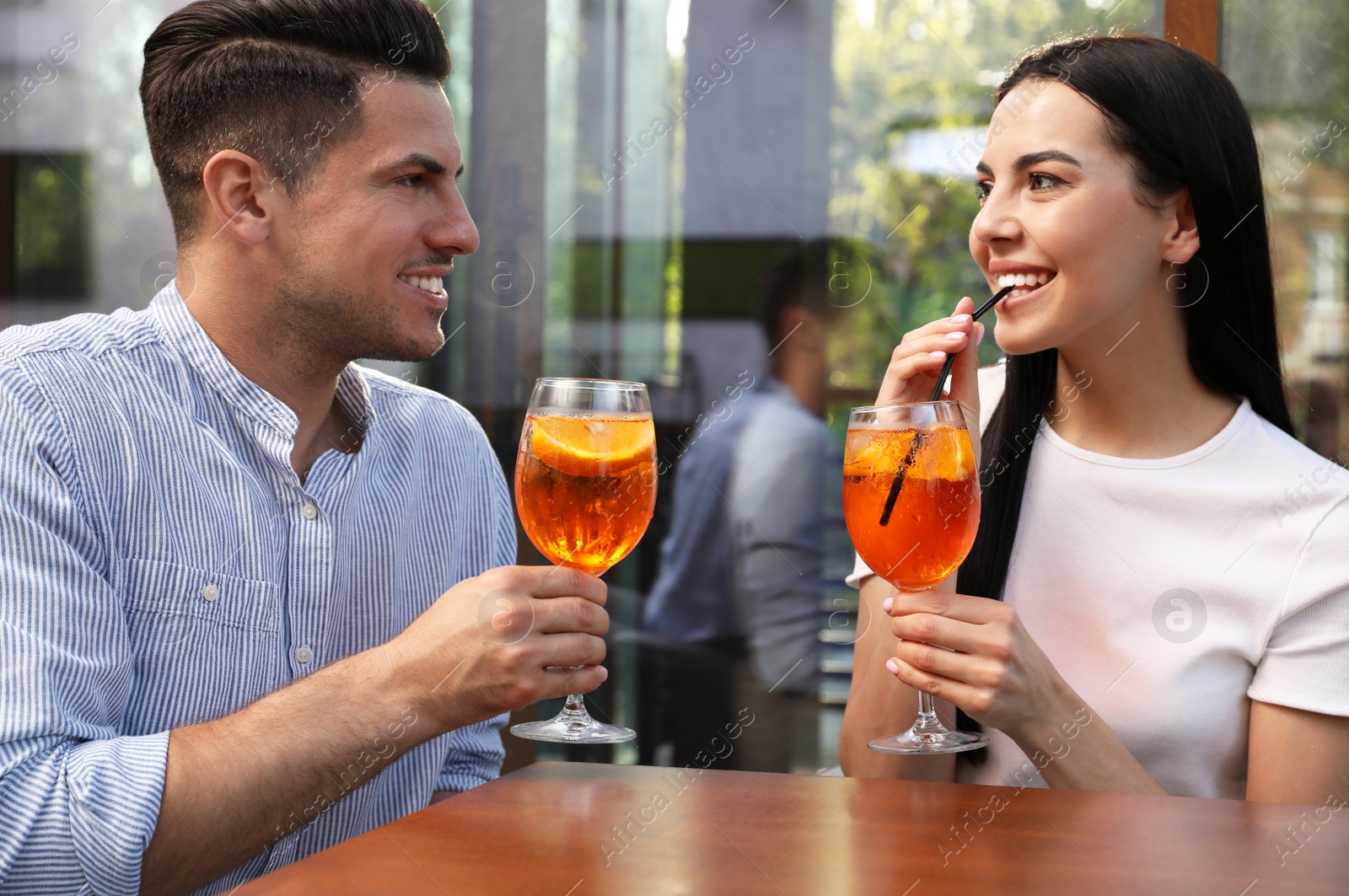 Photo of Happy couple with Aperol spritz cocktails outdoors