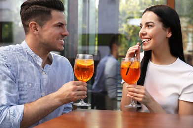 Photo of Happy couple with Aperol spritz cocktails outdoors
