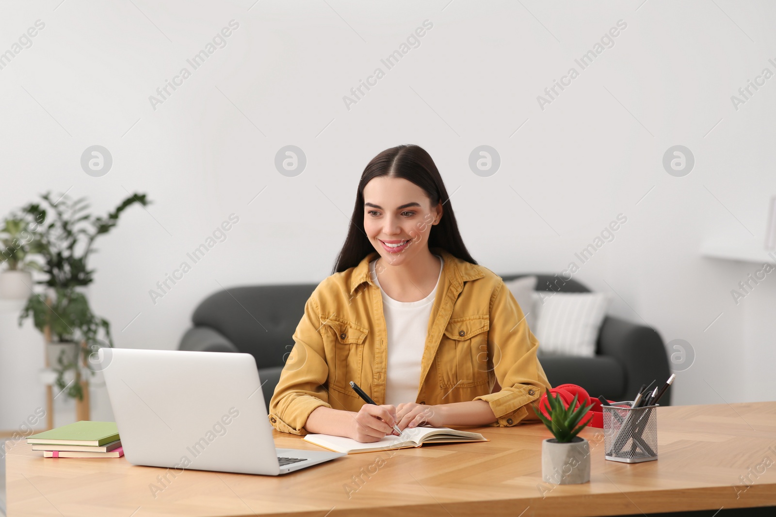 Photo of Woman studying on laptop at home. Online translation course