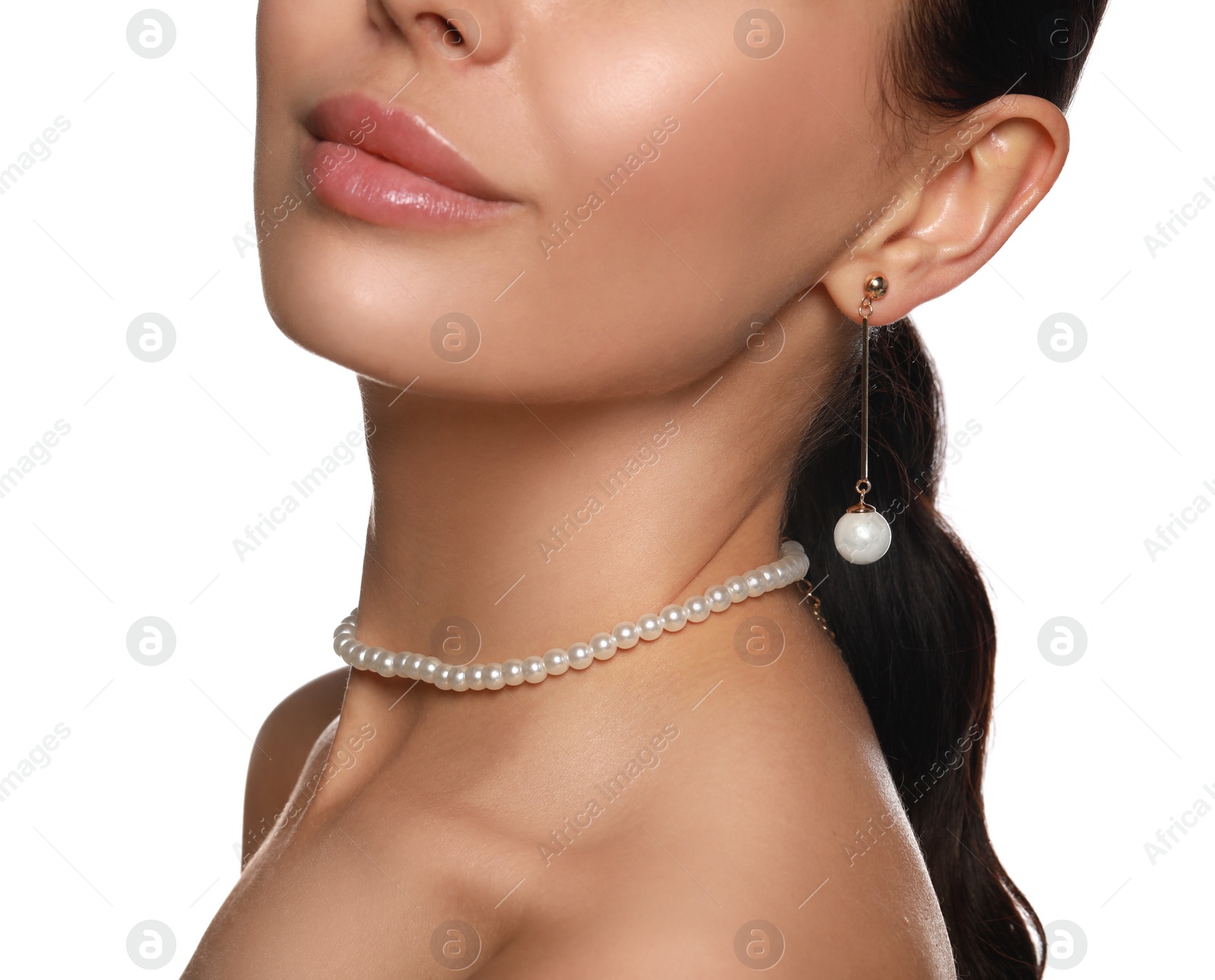 Photo of Young woman wearing elegant pearl jewelry on white background, closeup