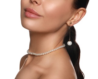 Young woman wearing elegant pearl jewelry on white background, closeup