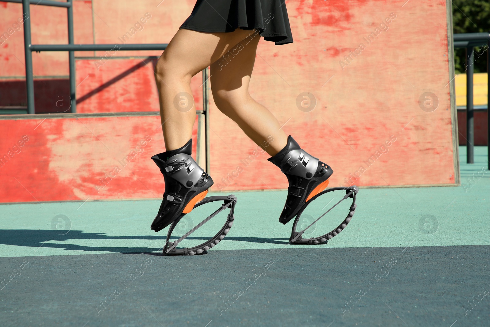 Photo of Woman doing exercises in kangoo jumping boots in workout park, closeup