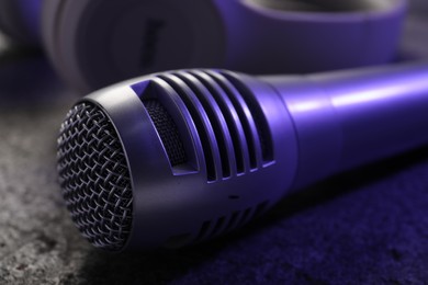 Photo of Microphone on grey textured table, closeup. Sound recording and reinforcement