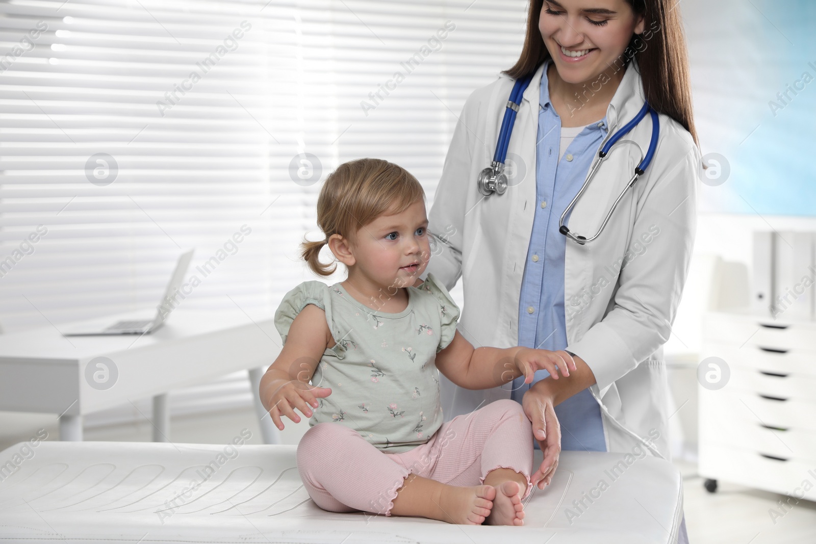 Photo of Pediatrician examining cute little baby in clinic