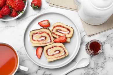 Photo of Tasty cake roll with strawberry jam and cream on white marble table, flat lay