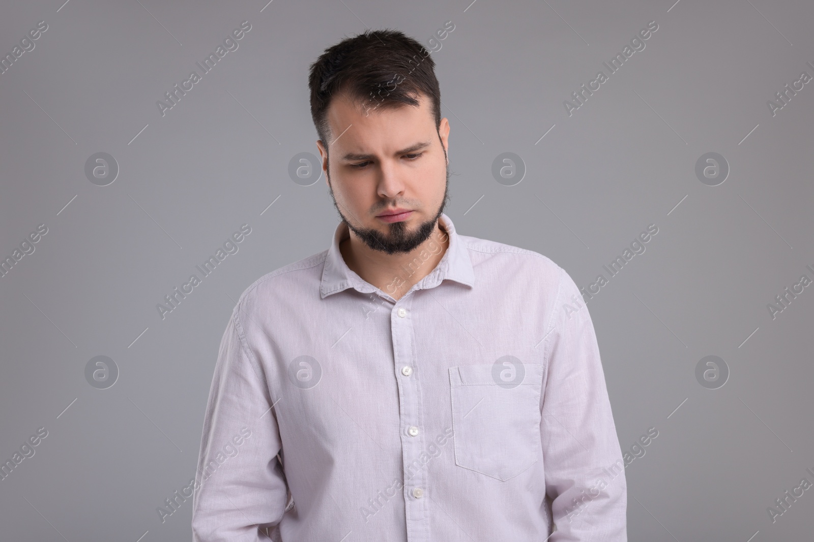 Photo of Portrait of sad man on grey background