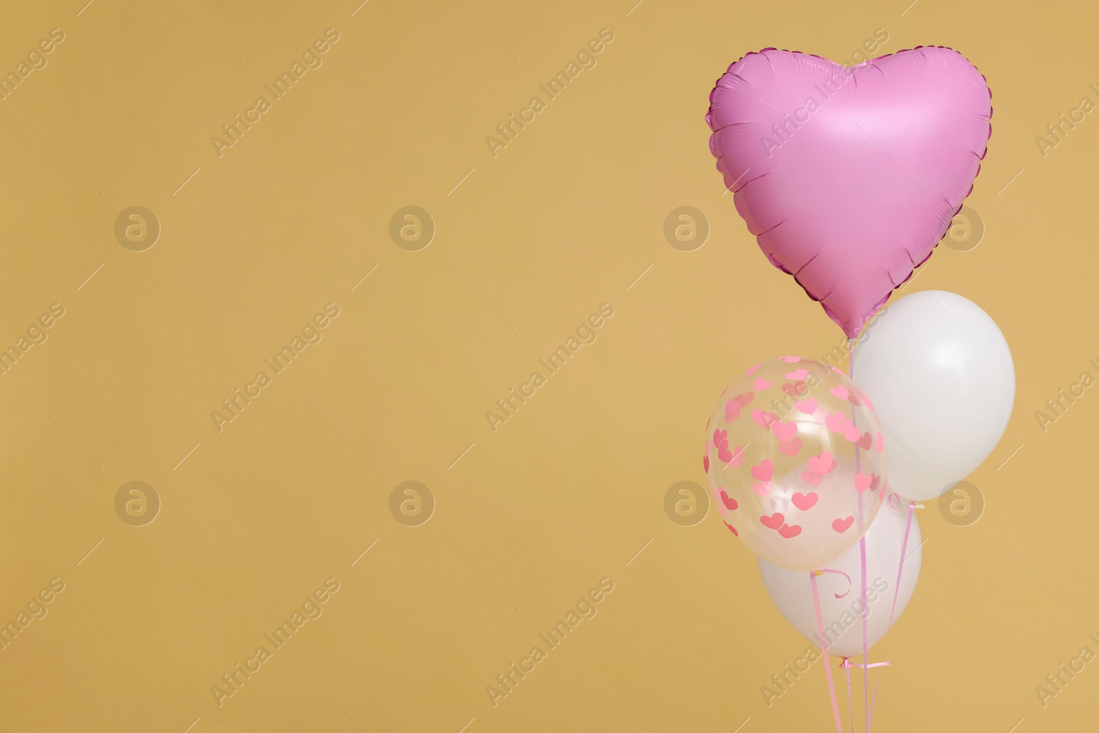 Photo of Bunch of heart and round shaped balloons on beige background, space for text. Birthday party