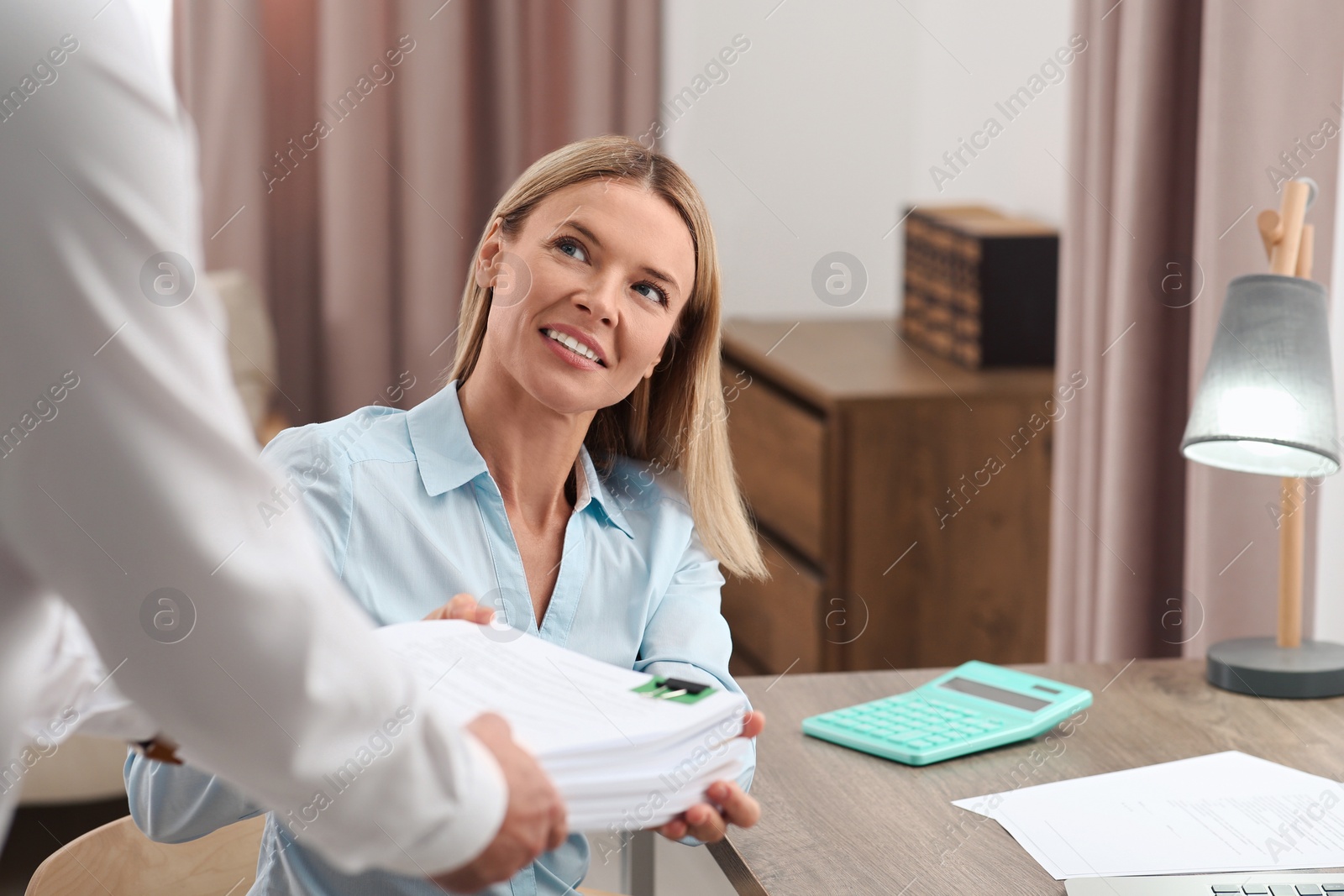 Photo of Woman giving documents to colleague in office, closeup