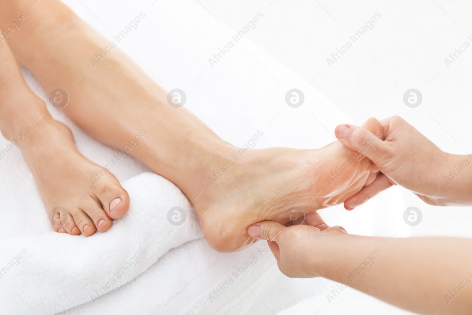 Photo of Woman receiving foot massage in wellness center, closeup