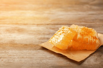 Image of Fresh honeycomb on wooden table, closeup. Space for text