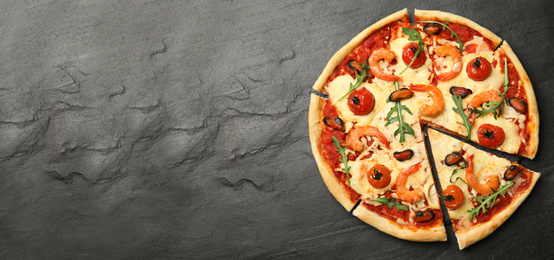 Image of Top view of hot delicious pizza on dark table, space for text. Banner design 