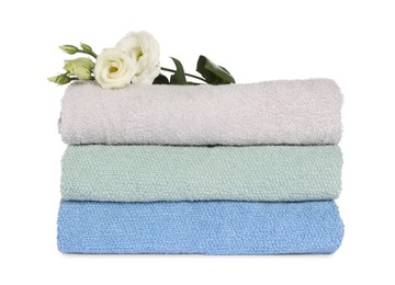 Photo of Stack of clean soft towels with flowers isolated on white